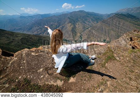 A Girl Sitting On A Rock On A Cliff In Canyon, Dagestan