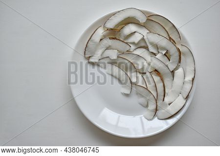 Slicing And Shavings Of Coconut On A White Plate