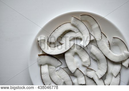 Slicing And Shavings Of Coconut On A White Plate