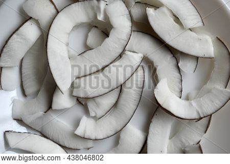 Slicing And Shavings Of Coconut On A White Plate