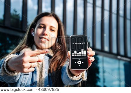 Audio Tour Online App On Digital Mobile Smartphone. Happy Young Student Woman Holding Phone Listenin