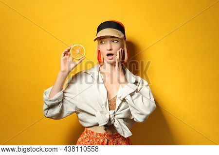 Emotional Young Woman With Bright Dyed Hair Holding Orange Half On Color Background