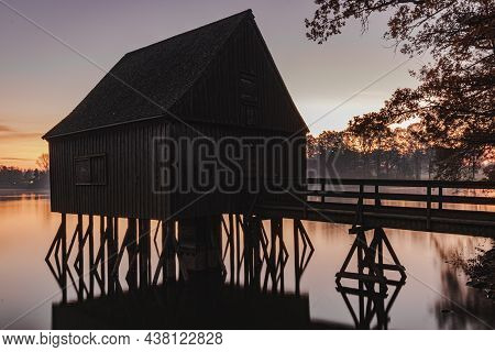 A Old Fisherman House With A Sunrise In The Background