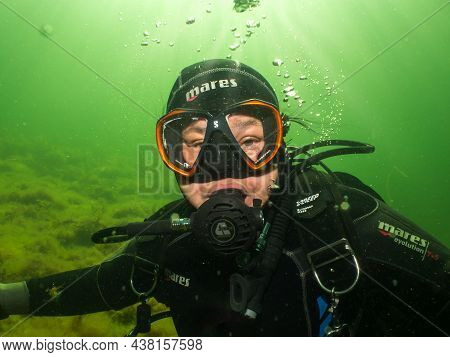 September 5, 2021 - Malmo, Sweden: A Female Scuba Diver Lit Up By Rays Of Sunlight Penetrating The W
