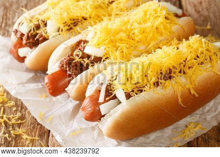 Cincinnati Fast Food Chili Hot Dog With Beef Sausage, Cheddar Cheese And Onions Close-up On An Old W