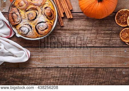 Cinnabon Cinnamon Rolls Buns With Pumpkin, Nut, Caramel And Sugar Cream Iced On Rustic Wooden Backgr