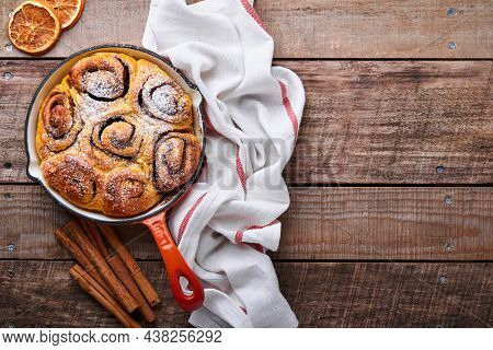 Cinnabon Cinnamon Rolls Buns With Pumpkin, Nut, Caramel And Sugar Cream Iced On Rustic Wooden Backgr