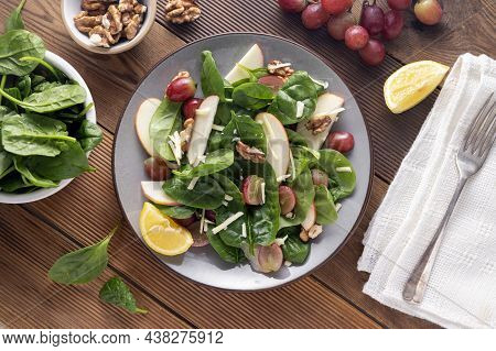 Healthy Spinach Salad Made With Red Apple, Wallnuts, Grapes. Wooden Rustic Background