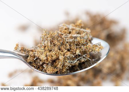 Spoon With Dried Wormwood Herb Isolated On White Background. Cose Up.