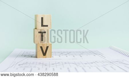 Three Wooden Cubes With Letters Ltv On White Paper With Diagramm