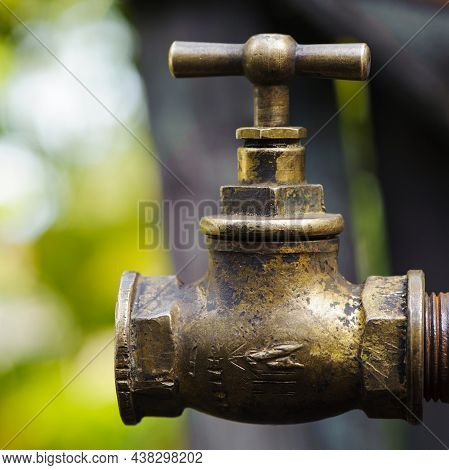 Old Brass Water Tap Isolated On A Light Background. Tap Valve. Old Copper Retro Faucet On A Rusty Pi