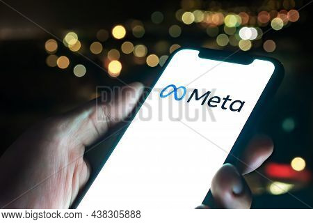 Malaga, Spain - 30 October 2021: Meta Logo In Mobile Phone Held By A Man. City Lights In The Backgro