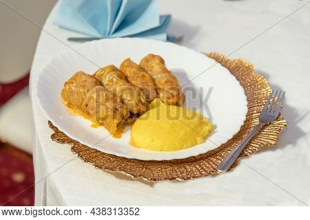 Sarmale With Polenta On White Plate On Restaurant Table