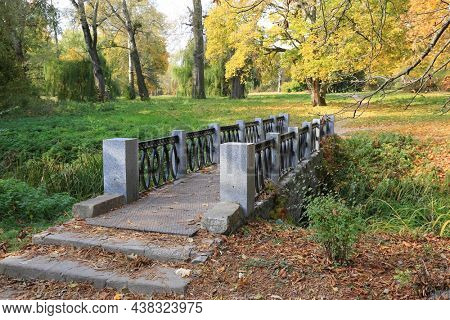 Old old bridge in autumn city park. Aleksandriya park in Ukraine