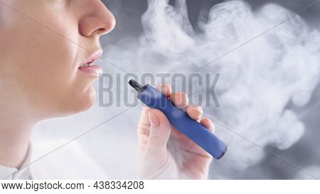 Caucasian Woman Smokes A Disposable Vape In The Studio.