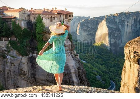 Young Woman In Green Dress And A Hat Enjoying Nature On The Mountains Near Meteora Monasteries. Gree