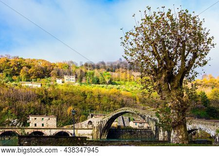 Italy, Lucca. The emerald cold water of the river reflects the ancient asymmetrical arches of the bridge. The bridge of Mary Magdalene crosses the Serchio River.