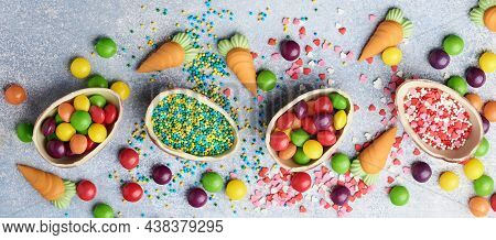 Chocolate Easter Eggs And Colorful Sweets On Gtay Background Greeting Card. Top View. Flat Lay With 