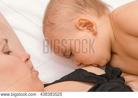 Breastfeeding. Mom Breast-feeds Baby Through A Special Bra For Feeding Babies