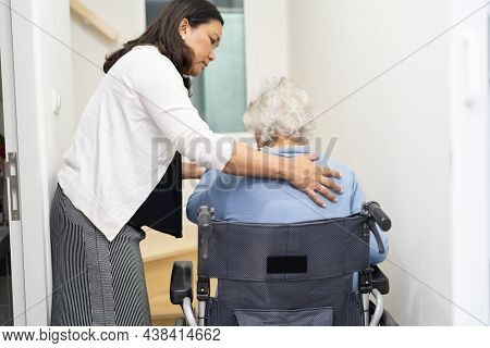 Caregiver Help Asian Or Elderly Old Woman Sitting Wheelchair Support Up The Stairs In Home.