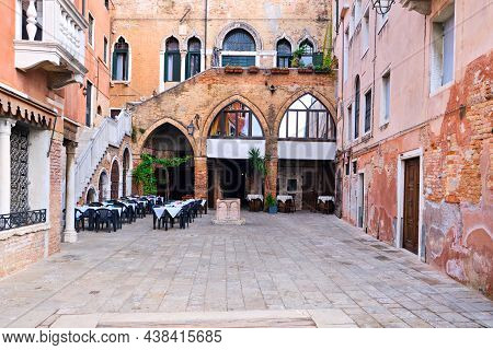 Venice, Veneto, Italy. Old Courtyard With Small Outdoor Cafe. Narrow Empty Little Backyard, Old Bric