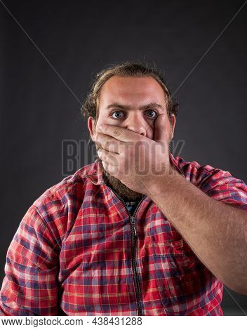 Man Holding Hand Over Mouth To Stop Saying Something And Is Being Shocked, Shoot In Studio