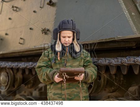 A Boy In A Tanker Uniform Near A Tank With A Bag In His Hands In Peacetime
