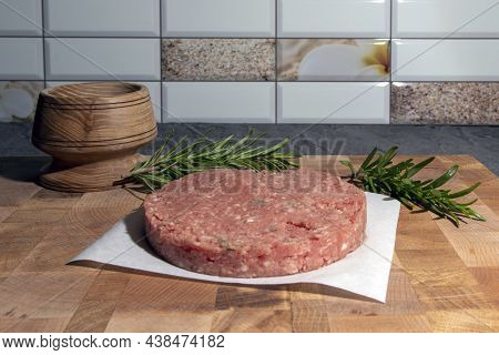 Fresh Raw Homemade Beef Burger Cutlets On A Cutting Board With Spices And Herbs.