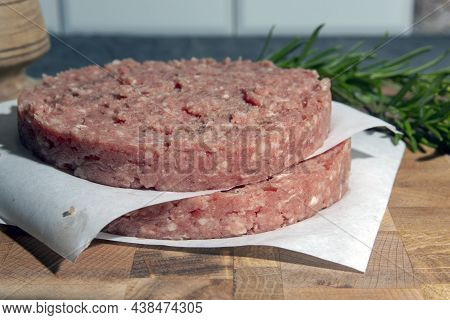 Fresh Raw Homemade Beef Burger Cutlets On A Cutting Board With Spices And Herbs.