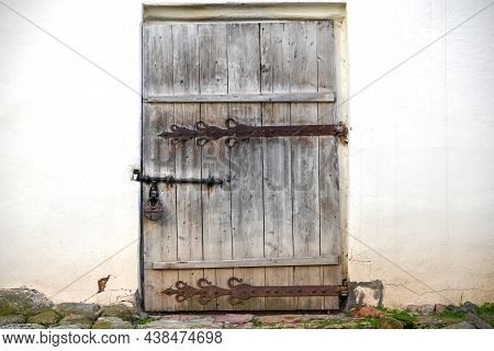 The Wooden Door Made Of Planks Is Decorated With A Decorative Element Of Wrought Iron In The Russian