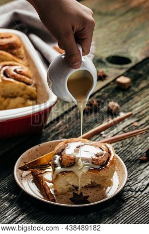 Homemade Sinnabon Buns With Cinnamon And White Cream Sauce. Sweet Traditional Dessert Buns.