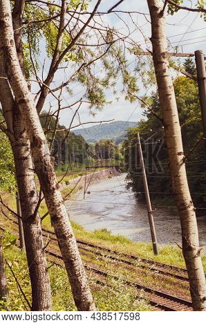 Railroad Among Mountains Covered With Dense Forest, Flowing Mountain River