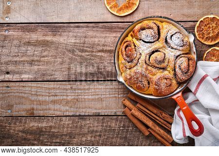 Cinnabon Cinnamon Rolls Buns With Pumpkin, Nut, Caramel And Sugar Cream Iced On Rustic Wooden Backgr
