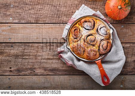 Cinnabon Cinnamon Rolls Buns With Pumpkin, Nut, Caramel And Sugar Cream Iced On Rustic Wooden Backgr