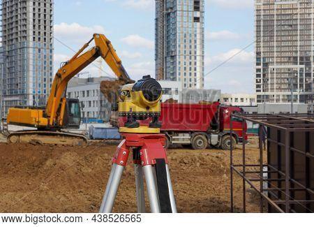 Photo Of A Level At The Construction Site Of Multi-storey Buildings With A Yellow Excavator And An R