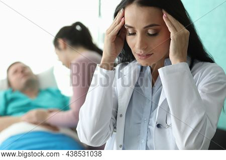 Doctor Holds His Head Near Sick Man Lying On Bed. Resuscitation And Intensive Care Unit. Care And Co