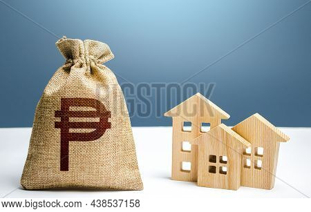 Philippine Peso Money Bag And Residential Buildings. City Municipal Budget. Property Tax. Investment
