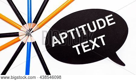 Wooden Card With The Text Aptitude Text On A Black Background Near Multicolored Pencils.
