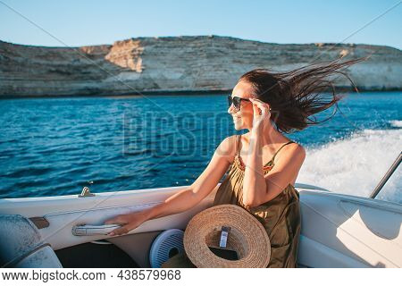 Woman In Hat And Dress Sailing On Boat In Clear Open Sea