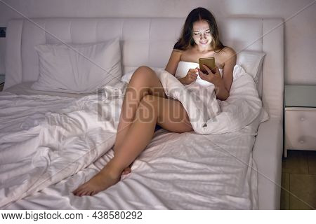 Online Dating By Phone, Half-dressed Woman Chatting On Internet Lying In Bed.
