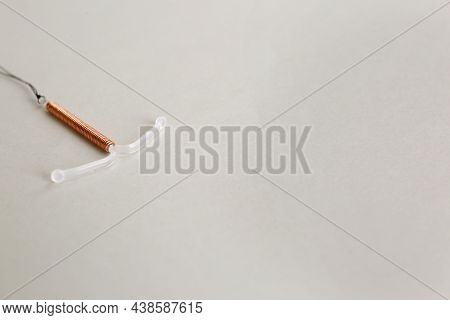 Copper Intrauterine Contraceptive Device On Light Background. Space For Text
