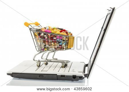 Tabletten mit Warenkorb und Computer. symbolische Foto für den Kauf von Medikamenten im Internet