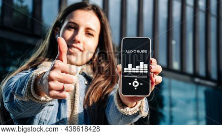 Audio Tour Online App On Digital Mobile Smartphone. Happy Young Student Woman Holding Phone Listenin