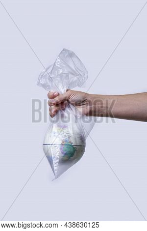 Global Warming And Climate Change Concepts. Woman Hand Holds A Glove In Plastic Bag. Environmental C