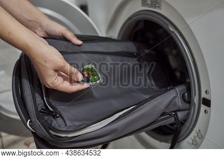 Washing And Cleaning Backpack In Washing Machine. Loading Dirty School Backpack Into Washing Machine
