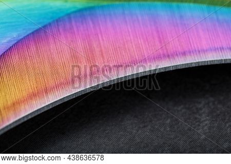 The Curved Sharp Blade Of The Kerambit Dagger Is A Gradient Rainbow Color On A Dark Background.