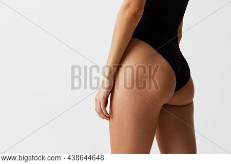 Back View Of Sportive Body, Bottocks Of Young Woman Isolated On Gray Studio Background. Natural Beau