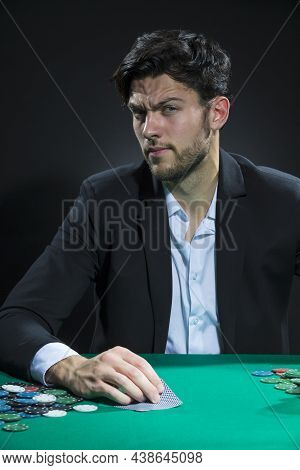Nervous And Concentrated Handsome Caucasian Brunet Young Pocker Player At Pocker Table With Chips Wh