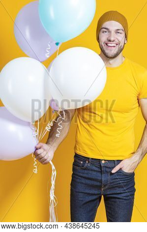 Celebrations Concepts. Funny Smiling Caucasian Young Handsome Man With Colorful Air Balloons Posing