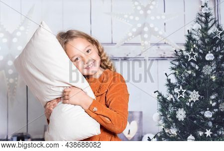 Little Girl In Red Dress At Home Holding Pillow On Christmas Dates